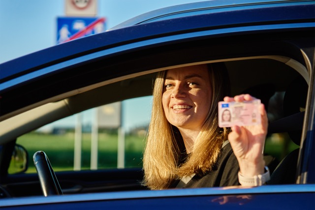 Donna felice con la patente di guida in auto